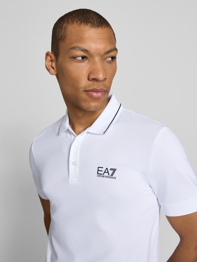 Männermodel trägt Regular Fit Poloshirt mit Logo-Print von EA7 Emporio Armani, weiß, glatte Textur, Nahaufnahme Oberkörper.