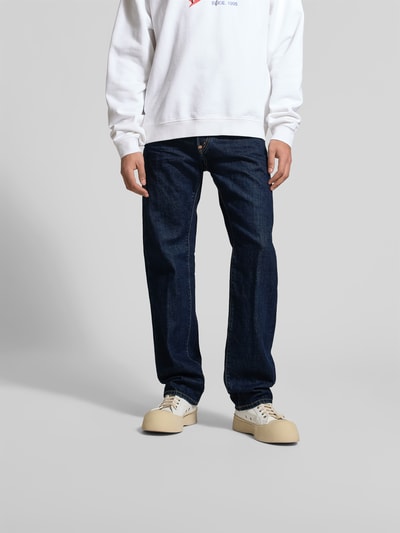Männermodel trägt Straight Fit Jeans aus reiner Baumwolle von Dsquared2 in Dunkelblau mit 5-Pocket-Design, Label-Detail, Knopf-Reißverschluss, Ganzkörperansicht von vorne.