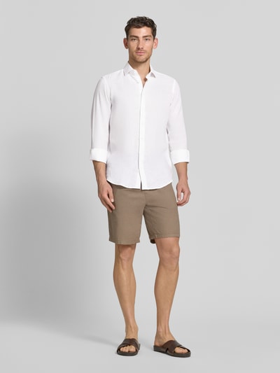 Männermodel trägt Regular Fit Leinenhemd mit Kentkragen von Christian Berg Men in Weiß, locker fallend, glatte Textur, Ganzkörperansicht von vorne.