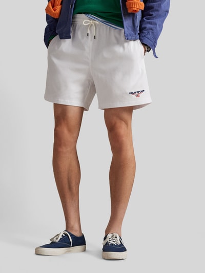 Männermodel trägt weiße Badeshorts mit Label Stitching von Polo Ralph Lauren, elastischer Bund, seitliche Taschen, Ganzkörperansicht von vorne.