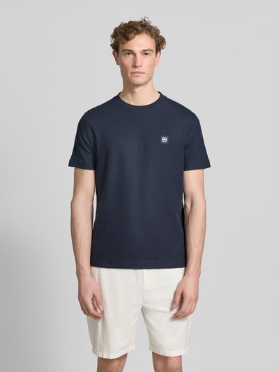 Männermodel trägt T-Shirt mit Label-Patch und Rundhalsausschnitt von Lerros, Reine Baumwolle, Gerader-Schnitt, dunkle Farbe, Ganzkörperansicht von vorne. Rückenlänge bei Größe M: 69 cm.