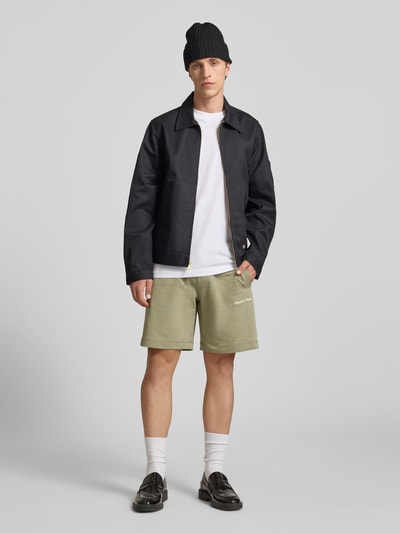 Männermodel trägt Shorts mit Label-Stitching Modell 'KARL' von Jack & Jones aus Baumwoll-Mix, Relaxed-Fit, Eingrifftaschen, Ganzkörperansicht von vorne.