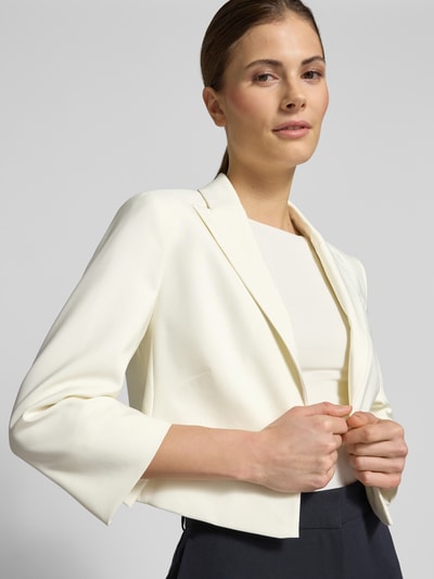 Vrouwenmodel draagt Cropped Blazer met Reverskragen van Betty Barclay in wit, elastische materiaalmix, open voorkant, 3/4-mouw, kort, borstwijdte 40 cm, ruglengte 41 cm, maat 36. Nahaufnahme bovenlichaam.