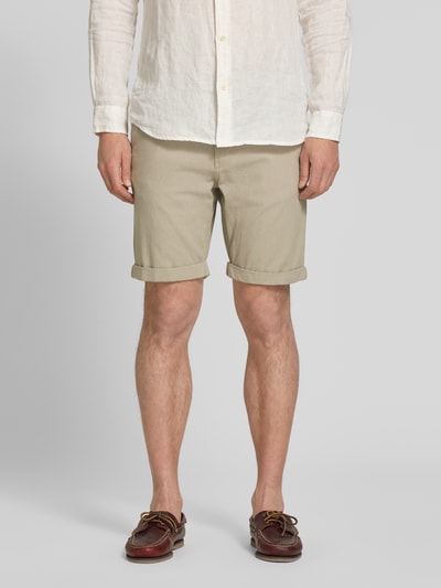 Männermodel trägt Slim Fit Chinoshorts aus Baumwoll-Mix Modell 'LUTON' von SELECTED HOMME, unifarben, feine Webstruktur, Nahaufnahme Oberschenkel, Vorderansicht.