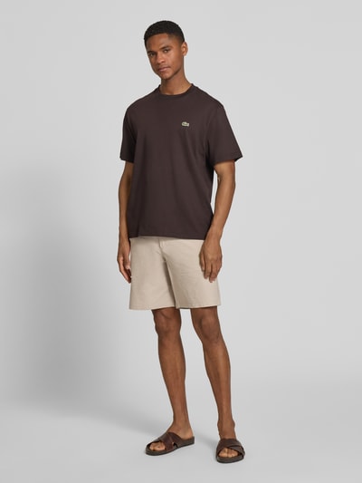 Męski model nosi Regular Fit Bermudas aus Baumwoll-Mix Modell 'KARL' von SELECTED HOMME, wzór w paski, mieszanka bawełny, seersucker, wpuszczane i tylne kieszenie, jasny beż, krój regular fit, zapięcie na guzik i kryty zamek błyskawiczny, szlufki na pasek, elastyczny pas, efekt: wzór na całej powierzchni, Ganzkörperansicht von vorne.
