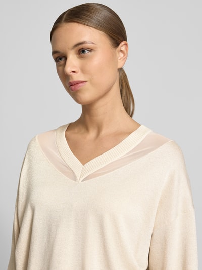 Frauenmodel trägt Relaxed Fit Pullover aus Viskose-Mix in Strick-Optik von LIU JO SPORT, semitransparente Partien, V-Ausschnitt, Nahaufnahme Oberkörper.