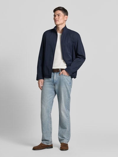 Mannenmodel draagt Regular Fit Blouson mit Logo-Stitching Modell 'H-CARVO' van BOSS, donkerblauw, lichte jeans, heren blouson, geheellichaamsfoto van voren.