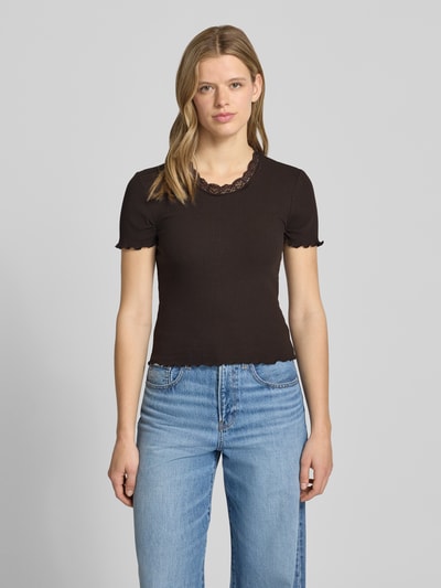 Kobiece model nosi damski t-shirt Slim Fit T-Shirt aus Baumwoll-Mix Modell 'VINI' od Only, jednokolorowy, aplikacja: obszycie koronką, okrągły dekolt, krótki rękaw, zakończenie: frędzle, wykończenie materiału: prążkowana mieszanka bawełny, całkowity widok z przodu.