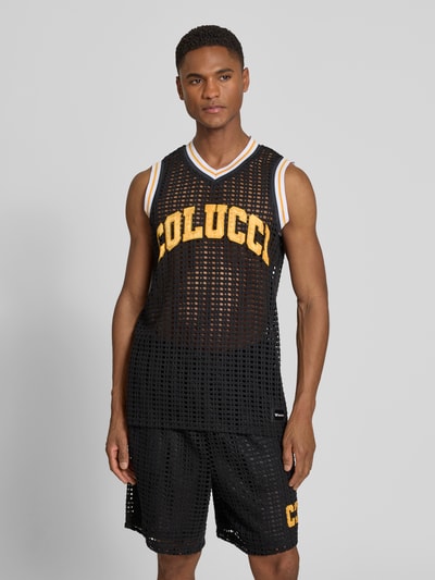 Männermodel trägt Relaxed Fit Tank Top in semitransparentem Design von COLUCCI, schwarze Netz-Optik, Logo-Stitching, Ganzkörperansicht von vorne.