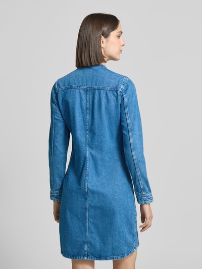 Vrouwenmodel draagt dames denimjurk van puur katoen, getailleerd model, mini-jurk, model 'PAOLA ALTO' van Mustang, ruglengte maat 36: 89 cm, borstwijdte 48 cm, mouwlengte 59 cm, geheel in blauw met zichtbare naden, ganzekörperansicht rückansicht.