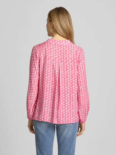 Vrouwenmodel draagt blouse uit zuiver viscose met serafinohals model 'Ja44nina' van ZABAIONE, los model in roze met wit motief, ruglengte bij maat S 65 cm, mouwlengte 56 cm, elastische mouwboord, ganzebody-aanzicht achteraan.