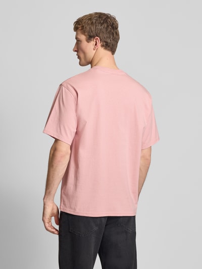 Männermodel trägt T-Shirt mit Label-Detail und Rundhalsausschnitt von Dickies in Rosa, reine Baumwolle, Relaxed Fit, Ganzkörperansicht Rückansicht