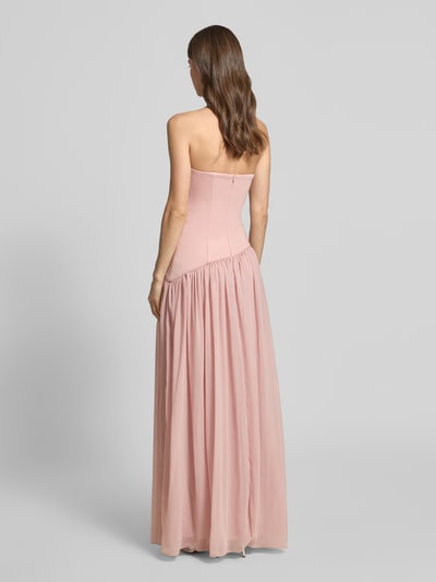 Frauenmodel trägt Abendkleid in Falten-Optik von Unique in Rosa, taillierte Passform, asymmetrisches Design, Maxilänge, schulterfrei, Ganzkörperansicht Rückansicht. Rückenlänge bei Größe 36: 133 cm, Brustweite bei Größe 36: 37 cm.
