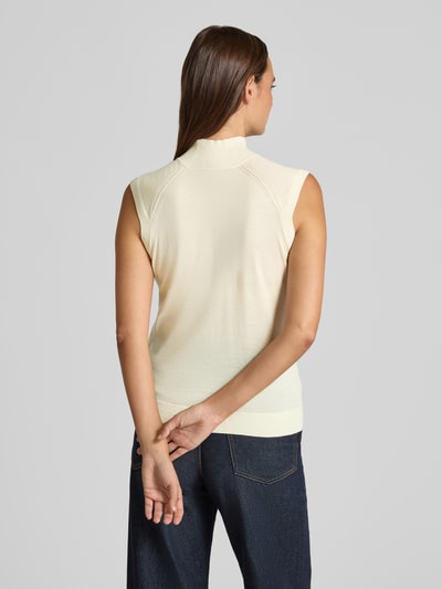 Frauenmodel trägt Slim Fit Pullunder aus reiner Schurwolle Modell 'FIPINI' von BOSS in Creme, feine Strickstruktur, Ganzkörperansicht Rückansicht. Damen Pullunder von BOSS.