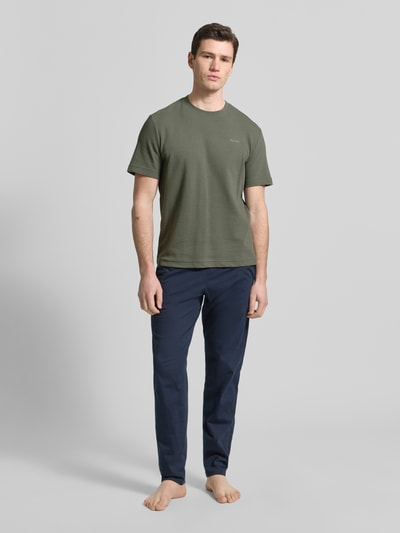 Männermodel trägt Regular Fit T-Shirt aus Baumwoll-Mix Modell 'AUSTIN' von HUGO in Optik: Unifarben mit Waffelstruktur, Label-Stitching-Applikation, Rundhals-Ausschnitt, Kurzarm, Ganzkörperansicht von vorne.