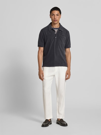 Männermodel trägt Tapered Fit Leinenhose von Closed in Weiß, elastischer Bund mit Tunnelzug, Eingrifftaschen, Ganzkörperansicht von vorne.