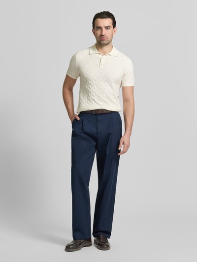 Männermodel trägt Regular Fit Poloshirt mit Strukturmuster von MCNEAL in Creme, kombiniert mit dunkelblauer Stoffhose, Ganzkörperansicht von vorne, reine Baumwolle, Strick-Optik, Polokragen.