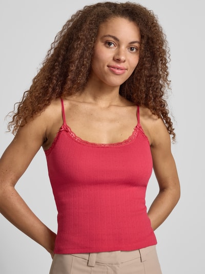 Frauenmodel trägt Slim Fit Top mit Spitzenbesatz von REVIEW in Rot, Reine Baumwolle mit Spaghettiträgern und Zierschleife, Ganzkörperansicht von vorne.