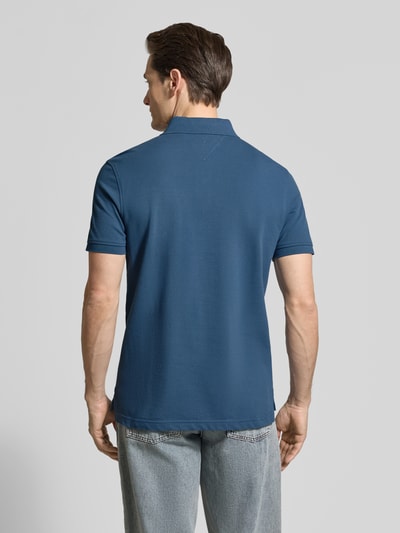 Männermodel trägt Regular Fit Poloshirt aus Baumwoll-Mix von Tommy Hilfiger, Optik: Unifarben, Piqué-Struktur, Ganzkörperansicht Rückansicht.