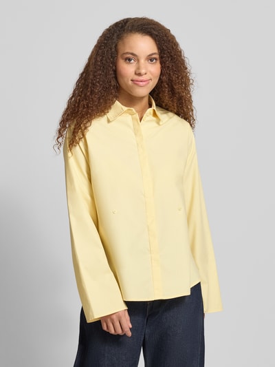 Frauenmodel trägt Regular Fit Bluse mit verdeckter Knopfleiste von Gina Tricot in Gelb, reine Baumwolle, Hemdblusenkragen, Ganzkörperansicht von vorne.