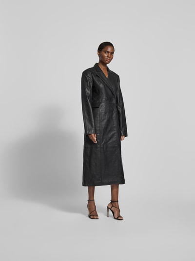 Frauenmodel trägt Mantel aus echtem Lammleder von ROTATE in Schwarz, taillierte Passform, Reverskragen, doppelte Knopfleiste, Taschen mit Überschlag, Rückenlänge 128 cm, Brustweite 46 cm, Ärmellänge 68 cm, glatte Lederstruktur, Ganzkörperansicht von vorne.