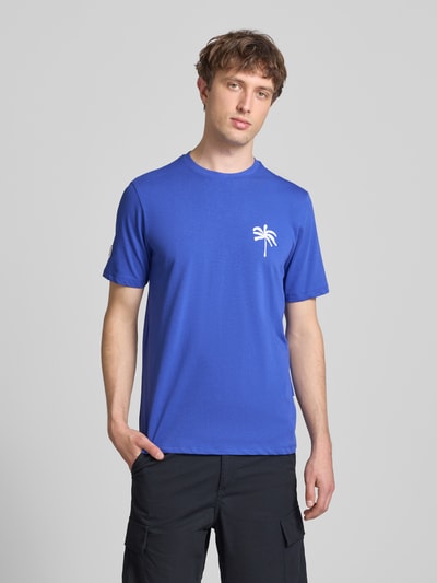 Männermodel trägt Herren T-Shirt mit Motiv-Print Modell 'SUN PALMS' von Blend in Blau, Reine Baumwolle, Regular-Fit, Rundhalsausschnitt, Rückenlänge bei Größe M: 73 cm, Ganzkörperansicht von vorne.