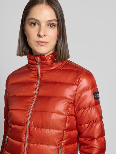 Frauenmodel trägt Regular Fit Jacke in Stepp-Optik von NAUTGÅRD in Orange, Kapuze mit Stehkragen, Reißverschluss, Nahaufnahme Oberkörper.