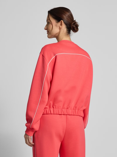 Frauenmodel trägt Regular Fit Jacke mit Viskose-Anteil Modell 'Kate' von ICHI in Koralle mit weißen Nähten, elastischer Bund, Rückenansicht, Ganzkörperansicht Rückansicht.