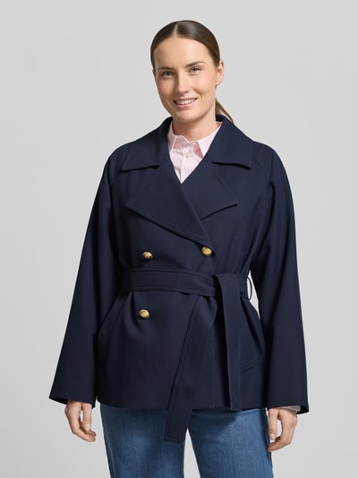 Vrouwenmodel draagt Jacke mit Reverskragen und Bindegürtel van Gant in donkerblauw materiaalmix met viscose, regular fit, met dubbele rij knopen, reverskraag, strikceintuur, ruglengte 68 cm, schouderbreedte 40 cm, borstwijdte 53 cm, mouwlengte 58 cm, voorkant borst en armen, ganzekörperzicht van voren.