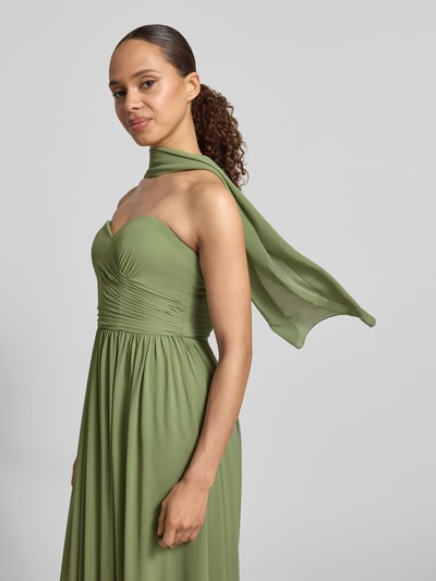 Frauenmodel trägt Maxikleid im Off-Shoulder-Look von Mascara aus grünem Chiffon, Taillierter Schnitt, Rückenreißverschluss, Nahaufnahme Oberkörper.