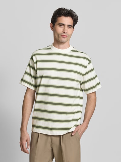 Męski model nosi Regular Fit T-Shirt mit Rundhalsausschnitt von Casual Friday, bawełna, krój regular fit, okrągły dekolt, krótki rękaw, długość tyłu w rozmiarze M: 74 cm, kremowe i zielone paski, całkowity widok z przodu.