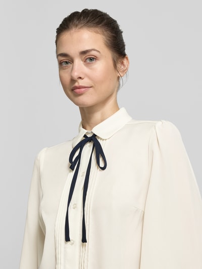 Frauenmodel trägt Regular Fit Bluse mit Bubikragen von Christian Berg Woman Selection in Creme mit Knopfleiste, Schnürung, Falten, Nahaufnahme Oberkörper. Rückenlänge 60 cm, Ärmellänge 65 cm in Größe 36.