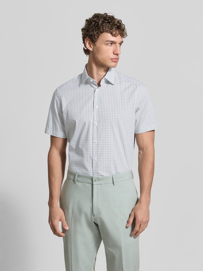 Männermodel trägt Regular Fit Business-Hemd aus Baumwolle mit Kentkragen von Christian Berg Men, feines Karo-Muster, helle Farben, Ganzkörperansicht von vorne.
