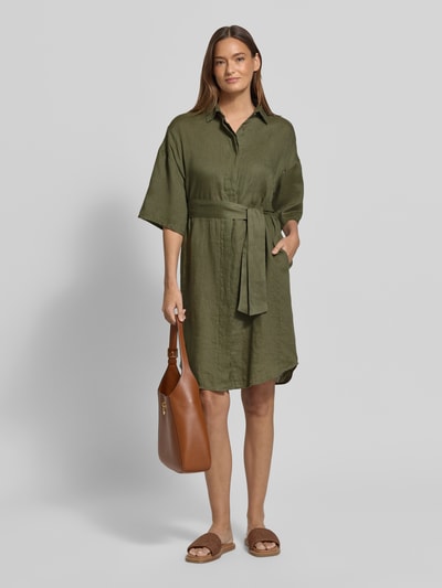 Modelka nosi Regular Fit Leinenkleid aus reinen Leinen Modell 'Derby' od 0039 Italy, zielony len, pasek z materiału, półprzezroczystość, krój taliowany, rękaw o dł. 1/2, wykładany kołnierz, listwa guzikowa na całej długości, długość tyłu w rozmiarze S: 96 cm, szerokość w rozmiarze S: 59 cm, długość rękawów w rozmiarze S: 24 cm, widok całej sylwetki z przodu.