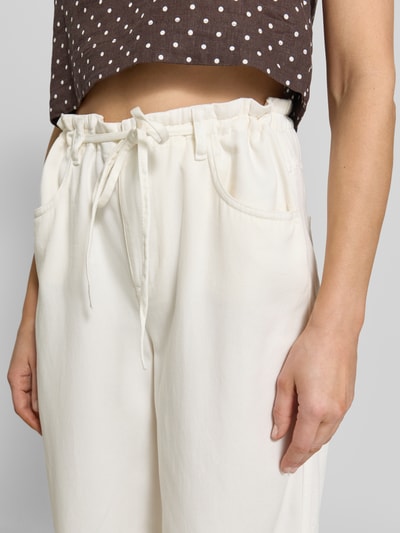 Frauenmodel trägt Hose aus Lyocell-Baumwoll-Mix mit Schnürung von Oui, weiße weite Beine, Eingrifftaschen, Nahaufnahme Oberkörper.