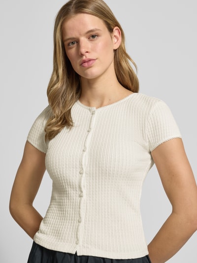Frauenmodel trägt Damen T-Shirt aus Reine Baumwolle, Slim-Fit, Modell 'AJOUR' von REVIEW mit durchgängiger Knopfleiste, Rundhalsausschnitt, kurzärmelig, feine Rippenstruktur, Rückenlänge bei Größe S 49 cm, helle Farbe, Nahaufnahme Oberkörper.