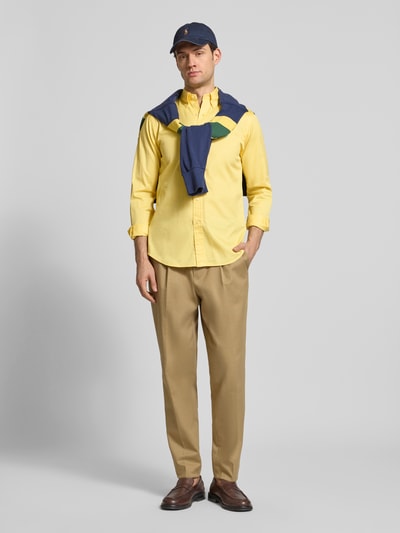 Männermodel trägt Regular Fit Freizeithemd aus reiner Baumwolle von Polo Ralph Lauren in Gelb, Twillstruktur, Ganzkörperansicht von vorne.