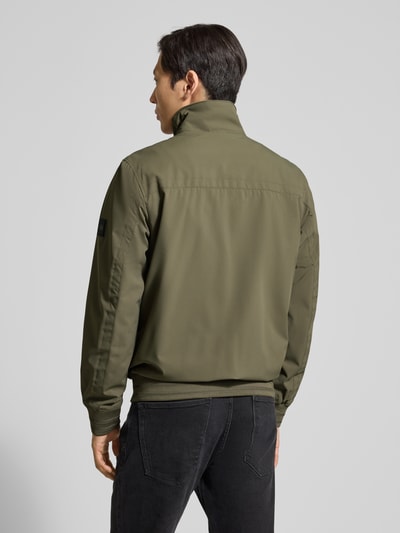Männermodel trägt Comfort Fit Blouson mit geripptem Rumpfabschluss von Tom Tailor in Oliv, Rückenpasse, langarm, Ganzkörperansicht Rückansicht.