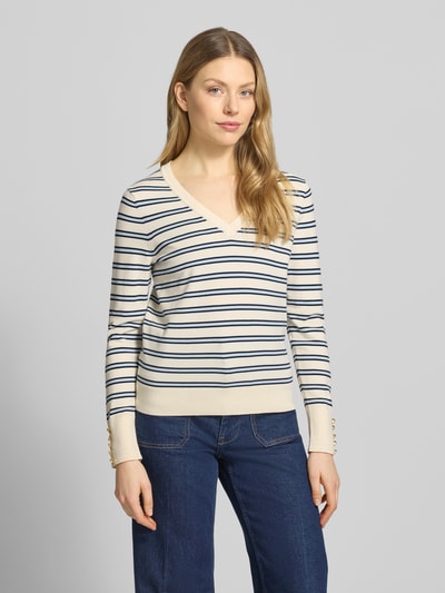 Vrouwenmodel draagt Regular Fit gebreide pullover uit puur katoen van Tommy Hilfiger, gestreepte look, gestikt logo, sierknopen, V-hals, lange mouw, geribde boorden, all-over motief, voorkant overzichten.