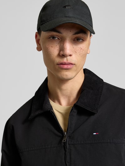 Männermodel trägt Regular Fit Ranch-Jacke aus reiner Baumwolle von Tommy Jeans, unifarben, Nahaufnahme Oberkörper.