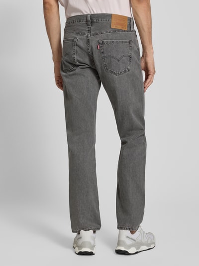 Männermodel trägt Straight Fit Jeans aus reiner Baumwolle Modell '501®' von Levi's®, graue Denim-Optik, Label-Patch, 5-Pocket-Design, Ganzkörperansicht Rückansicht.