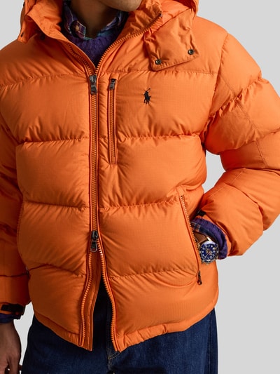 Männermodel trägt Steppjacke mit Zweiwege-Reißverschluss von POLO RALPH LAUREN in Orange, Polyester, unifarben, Nahaufnahme Oberkörper.