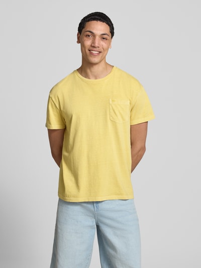 Männermodel trägt T-Shirt aus Baumwoll-Leinen-Mix mit Brusttasche von Superdry in Gelb, Regular-Fit, Rundhalsausschnitt, Herren T-Shirt, Rückenlänge bei Größe M: 66 cm, Ganzkörperansicht von vorne.