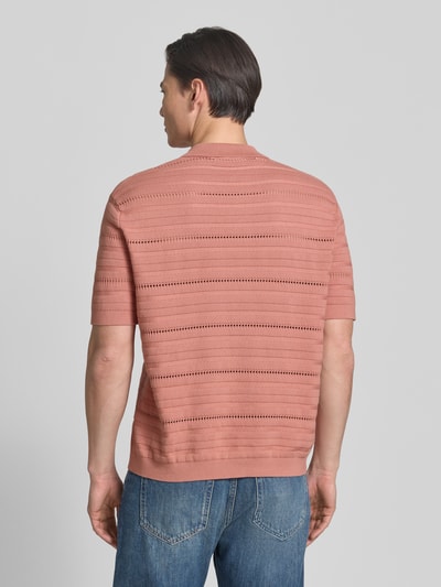 Männermodel trägt Regular Fit Strickjacke aus reiner Baumwolle Modell 'PALLE' von SELECTED HOMME in Ziegelrot, Strickstruktur, Ganzkörperansicht Rückansicht.