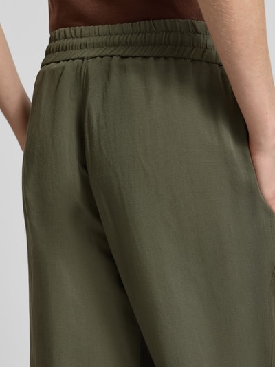 Frauenmodel trägt Leinenhose mit elastischem Bund Modell 'Roma' von STEHMANN in Olive, Wide-Leg-Pants aus Reine Leinen, Detailaufnahme.
