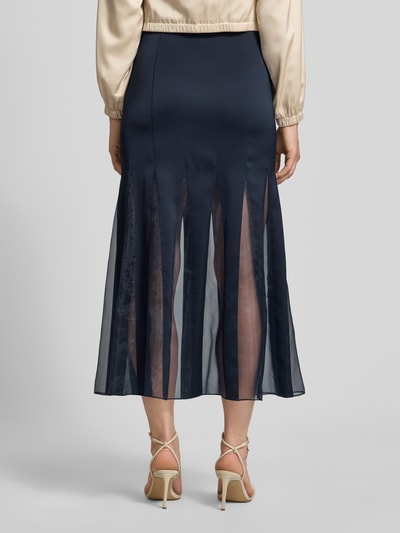 Kobiece modelka nosi długa spódnica z transparentnymi wstawkami Damen Maxi-Rock mit transparenten Einsätzen Modell 'VABELLI' von BOSS, ciemnogranatowy kolor, gładki materiał, długość maxi, widoczne tekstury, Ganzkörperansicht Rückansicht.