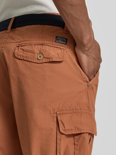 Männermodel trägt Regular Fit Bermudas mit Cargo-Taschen von Petrol in Rostbraun, reine Baumwolle, mit Gesäßtaschen, Detailaufnahme Rückansicht.