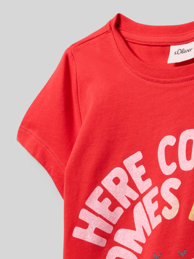 Mädchen trägt Regular Fit T-Shirt mit Glitzer-Print von s.Oliver RED LABEL in Rot, Optik: Unifarben, Rundhals, reine Baumwolle, Nahaufnahme Oberkörper.
