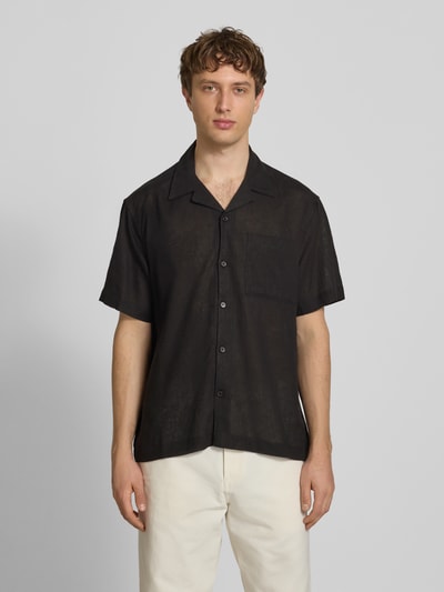 Männermodel trägt Relaxed Fit Freizeithemd aus Leinen-Viskose-Mix Modell 'LAURENCE' von Only & Sons, Optik: Unifarben, Passform: Relaxed-Fit, Hemdkragen: Reverskragen, Knopfleiste: Einreihig, Ärmelform: Kurzarm, Brusttasche; Glatte Textur, Schwarz, Ganzkörperansicht von vorne.
