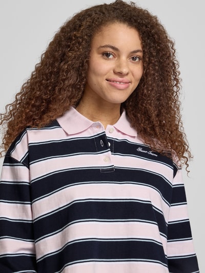 Frauenmodel trägt Cropped Poloshirt mit Label-Stitching von Guess Jeans aus Reine Baumwolle mit Knopfleiste, Longsleeve, Nahaufnahme Oberkörper.